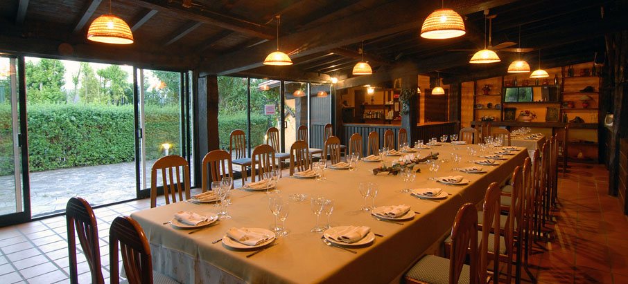 Salón montado para una celebración, con el jardín al fondo